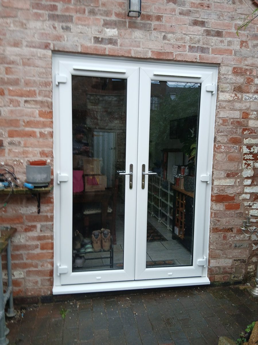 White uPVC French doors in a brick wall