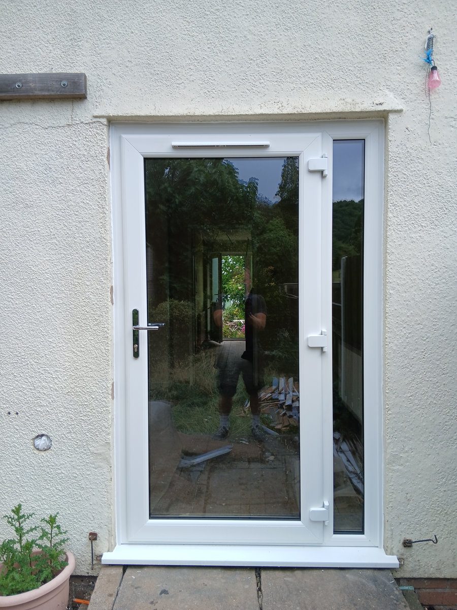 White uPVC glazed front door with side panel