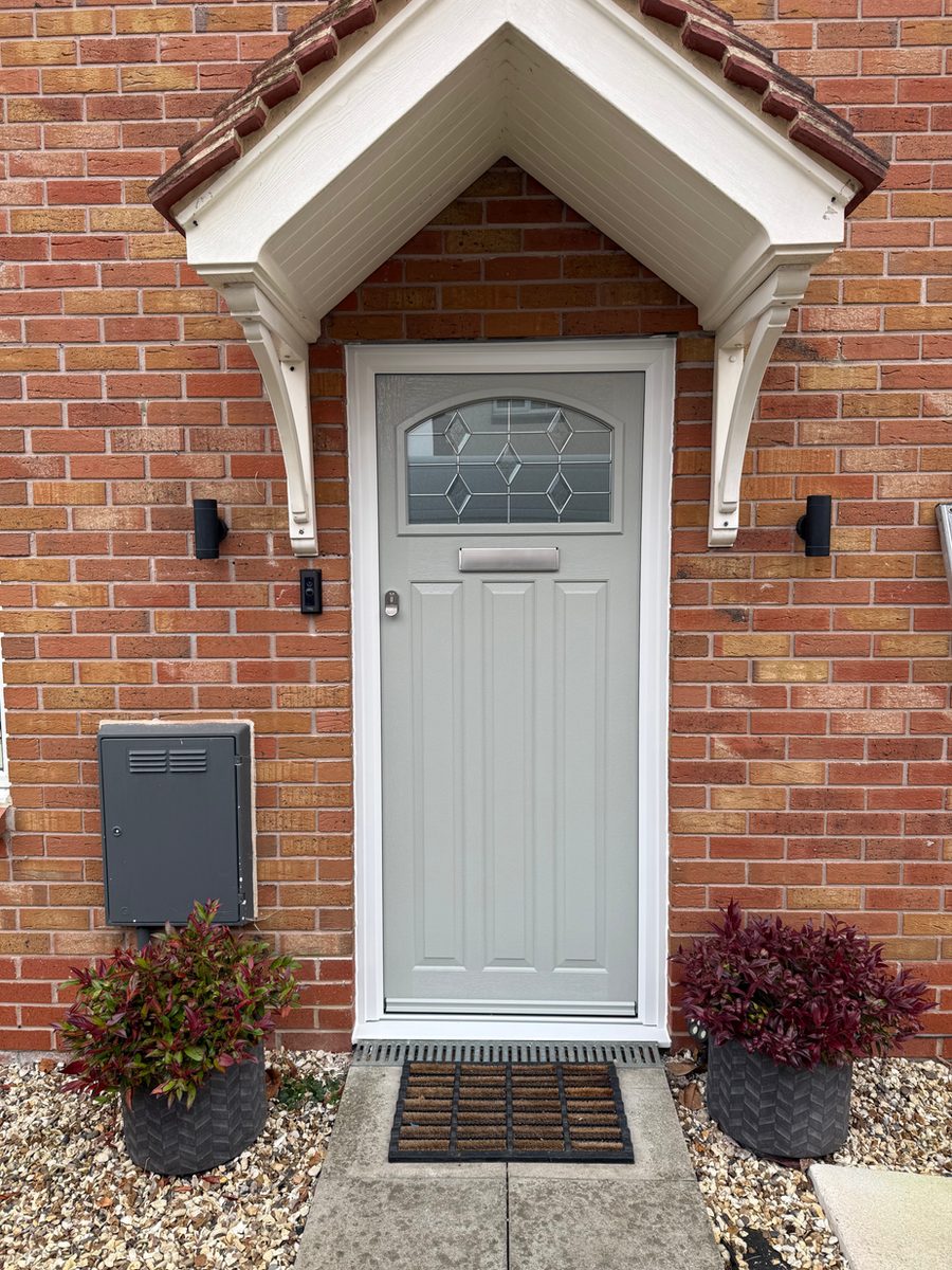 Cream front door with decorative glass under a canopy